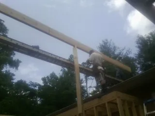 Carpenter setting a ridge beam over a new addition frame — Ice Dam Removal by Roofing Brothers in Lucernemines