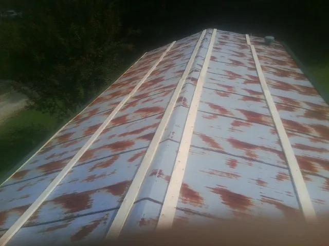 Rusted metal roof panels with new wood purlins before replacement — Storm Damage Roof Repair in Lucernemines by Roofing Brothers