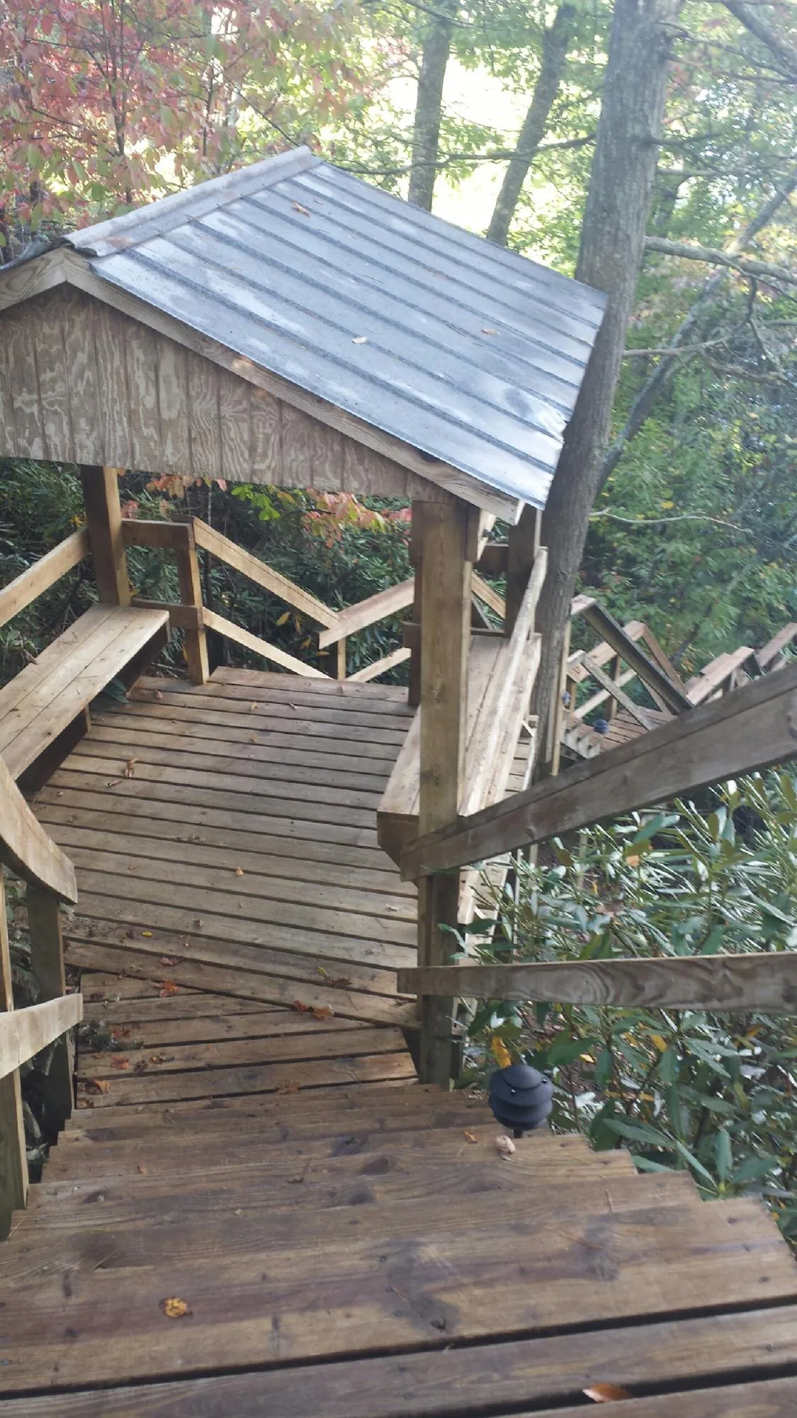Metal roofed shelter over wooden steps on a wooded walkway — Skylight Repair & Installation work by our crew in Lucernemines