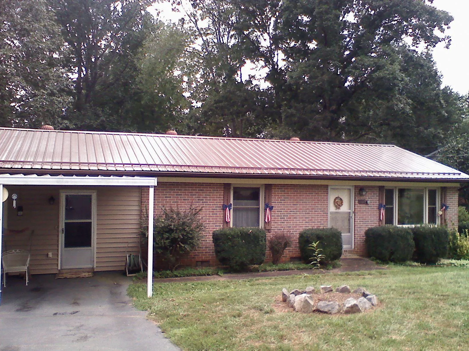 Bronze metal roof and carport on a brick ranch home — Roof Repair work by our crew in Lucernemines